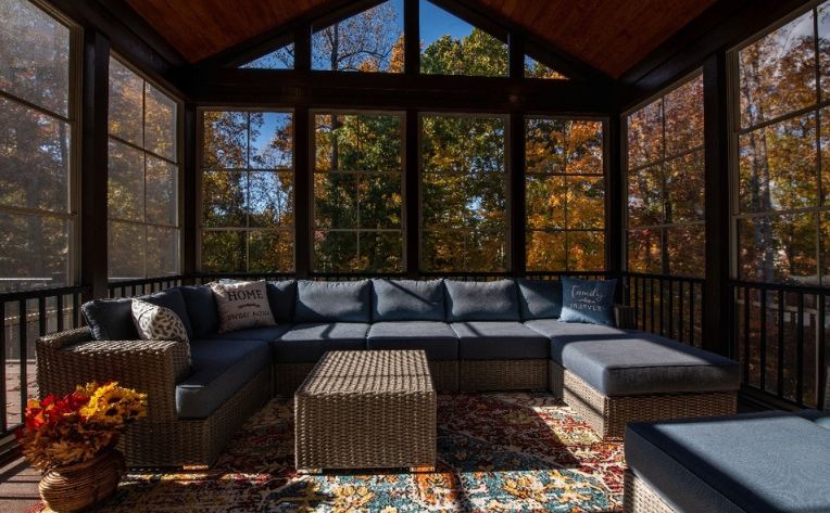 Interior of a sunroom covered with a carpet and grey seating 